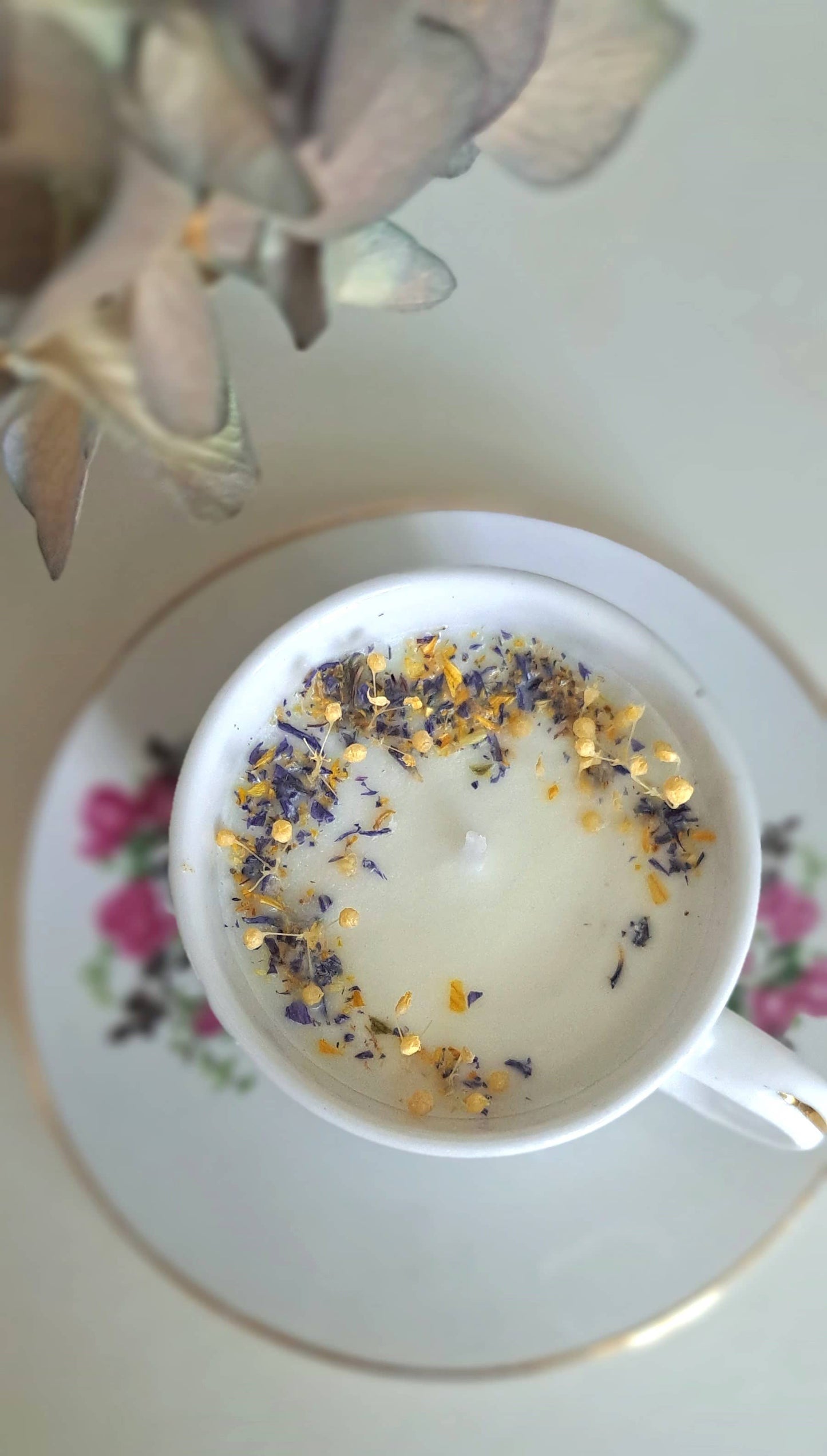 Bougie parfumée dans tasse ancienne avec des fleurs séchées 1